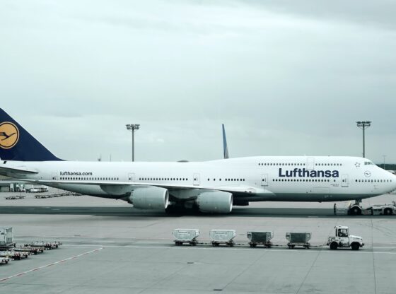 white and black Lufthansa airliner near vehicles